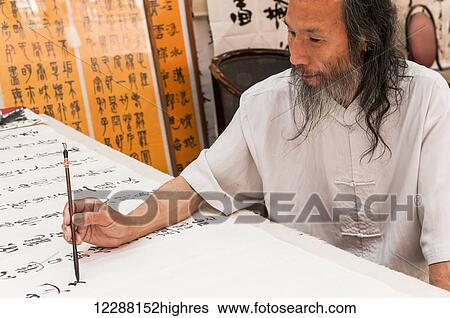 A Chinese man writes characters in his street shop; Xian, Shaanxi province, China View Large Photo Image Stock Photograph - A Chinese man writes characters in his street shop; Xian, Shaanxi province, China. Fotosearch