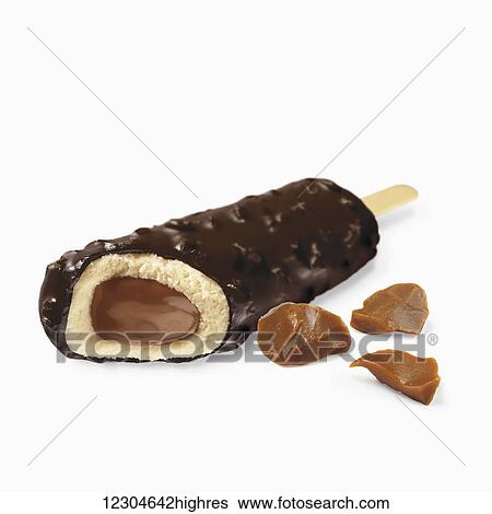 Stock Photograph - A chocolate covered ice cream treat filled with caramel on a white background; Toronto, Ontario, Canada. Fotosearch
