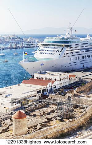 A color image of a small cruise ship docked in port in Rhodes, Greece with parts of the ancient city under restoration in the foreground; Mandraki, Rhodes, Greece View Large Photo Image Stock Photograph - A color image of a small cruise ship docked in port in Rhodes, Greece with parts of the ancient city under restoration in the foreground; Mandraki, Rhodes, Greece. Fotosearch