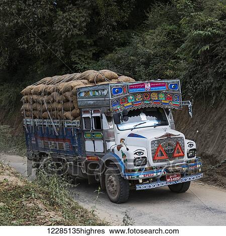 Stock Photograph - A colourful truck loaded with brown sacks; Thimphu, Bhutan. Fotosearch