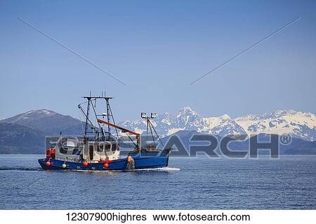 A commercial fishing boat on the waters of Main Bay with the Chugach Mountains in the background, Prince William Sound, Whittier, Southcentral Alaska, USA View Large Photo Image Stock Photograph - A commercial fishing boat on the waters of Main Bay with the Chugach Mountains in the background, Prince William Sound, Whittier, Southcentral Alaska, USA. Fotosearch