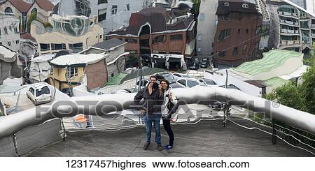 A couple distorted by window glass standing on a balcony with a view of buildings in the background below, Leeum samsung museum of art; Seoul, South Korea View Large Photo Image Stock Photograph - A couple distorted by window glass standing on a balcony with a view of buildings in the background below, Leeum samsung museum of art; Seoul, South Korea. Fotosearch