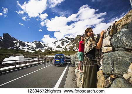 A couple holding on to a rock wall along the Great St. Bernard Pass, one of the most ancient passes through the Western Alps, going through Italy and Switzerland; Italy View Large Photo Image Stock Photograph - A couple holding on to a rock wall along the Great St. Bernard Pass, one of the most ancient passes through the Western Alps, going through Italy and Switzerland; Italy. Fotosearch