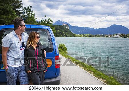 A couple looks out at the Church on the Island; Bled, Slovenia View Large Photo Image Stock Photograph - A couple looks out at the Church on the Island; Bled, Slovenia. Fotosearch