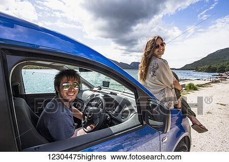 Stock Photograph - A couple plays together at a secluded beach along the Croatian coastline; Zaton Doli, Croatia. Fotosearch