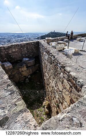 A couple sits on a stone wall overlooking the city; Athens, Greece View Large Photo Image Stock Photograph - A couple sits on a stone wall overlooking the city; Athens, Greece. Fotosearch