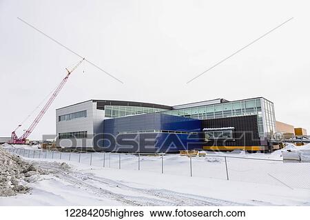 Stock Photograph - A crane towers over an unfinished hospital, Barrow, North Slope, Arctic Alaska, USA, Winter. Fotosearch