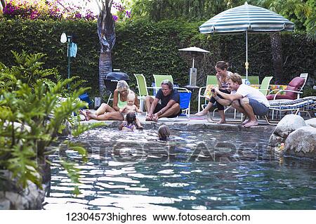 Stock Photograph - A family enjoys an afternoon in the pool on a sunny afternoon; Fountain Valley, California, United States of America. Fotosearch
