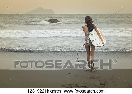 A female surfer carries her longboard into the sea, Waiao beach in Yilan County; Taiwan, China View Large Photo Image Stock Photograph - A female surfer carries her longboard into the sea, Waiao beach in Yilan County; Taiwan, China. Fotosearch