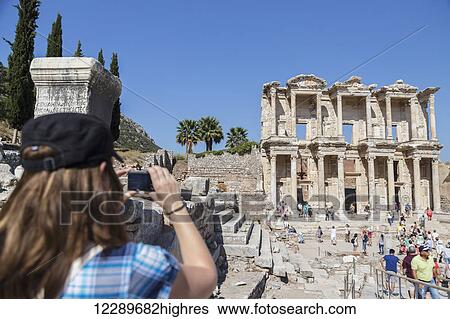 A female tourist takes a photo of the Library of Celsus in the ruins of Ephesus; Ephesus, Izmir, Turkey View Large Photo Image Stock Photograph - A female tourist takes a photo of the Library of Celsus in the ruins of Ephesus; Ephesus, Izmir, Turkey. Fotosearch