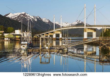 A fishing boat docked on the calm waters in the Sitka Harbor with the O'Connell bridge in the background, Sitka, Southeast Alaska, USA, Summer View Large Photo Image Stock Photograph - A fishing boat docked on the calm waters in the Sitka Harbor with the O'Connell bridge in the background, Sitka, Southeast Alaska, USA, Summer. Fotosearch