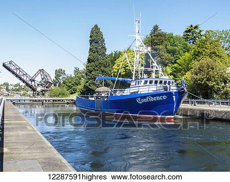 A fishing boat floats in a lock with a raised draw bridge in the background, Ballard Locks, Seattle, Washington, USA, Summer View Large Photo Image Stock Photograph - A fishing boat floats in a lock with a raised draw bridge in the background, Ballard Locks, Seattle, Washington, USA, Summer. Fotosearch