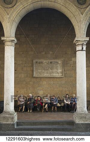 A group of elderly women sit on a beach along a stone wall; Orvieto, Umbria, Italy View Large Photo Image Stock Photograph - A group of elderly women sit on a beach along a stone wall; Orvieto, Umbria, Italy. Fotosearch