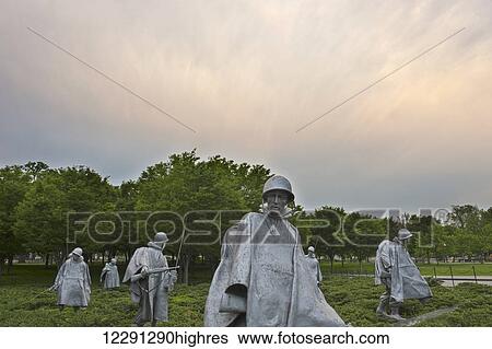 Stock Photograph - A group of statues represent a squadron on patrol at the Korean War Veterans Memorial in Washington, D. C. with the Washington Monument in the background; Washington, District of Columbia, United States of America. Fotosearch