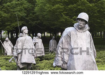 Stock Photograph - A group of statues represent a squadron on patrol at the Korean War Veterans Memorial in Washington, D. C. with the Washington Monument in the background; Washington, District of Columbia, United States of America. Fotosearch