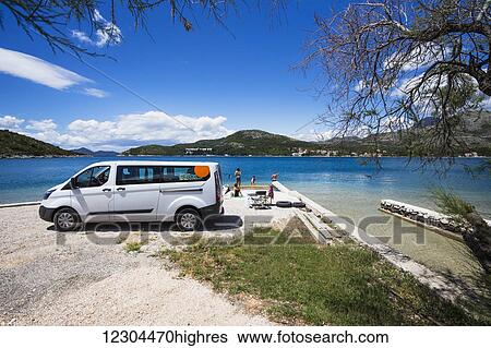 Stock Photograph - A group stops for an afternoon at the beach; Slano, Croatia. Fotosearch