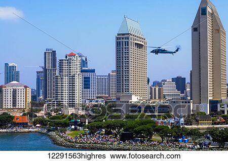 Stock Photograph - A helicopter hovers as crowds gather at the shore in downtown San Diego; San Diego, California, United States of America. Fotosearch