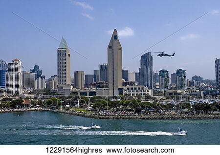 Stock Photograph - A helicopter hovers as crowds gather at the shore in downtown San Diego; San Diego, California, United States of America. Fotosearch