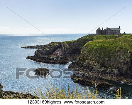 Stock Photograph - A house above the cliffs on Moray Firth Coast; Aberdeenshire, Scotland. Fotosearch