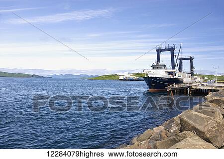 Stock Photograph - A large cargo ship docked at Sand Point Harbor, Southwestern Alaska, USA, Summer. Fotosearch