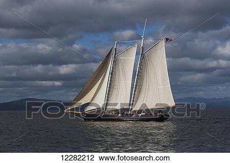 A large sailboat sails down the Columbia River; Astoria, Oregon, United States of America View Large Photo Image Stock Image - A large sailboat sails down the Columbia River; Astoria, Oregon, United States of America. Fotosearch