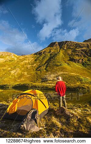 Stock Photograph - A man at his campsite at Hanging Valley in South Fork near Eagle River on a summer day in South Central Alaska.. Fotosearch