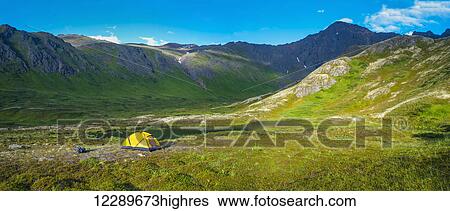 Stock Photograph - A man at his campsite at Hanging Valley in South Fork near Eagle River on a summer day in South Central Alaska.. Fotosearch