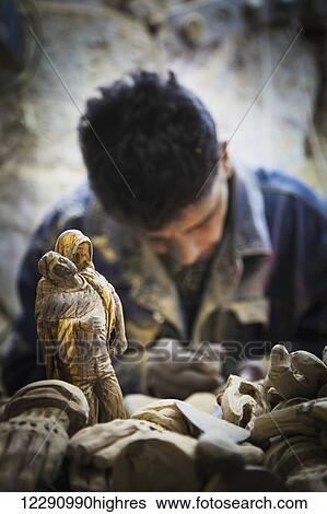 Stock Photograph - A man hand carves figurines; Bethlehem, Jerusalem. Fotosearch