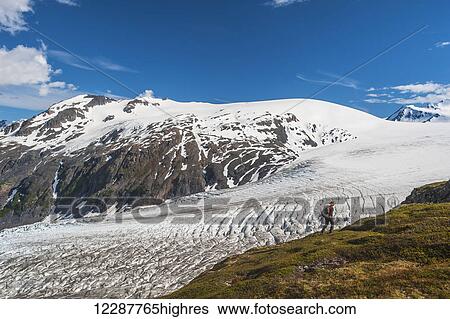 Stock Photograph - A man hiking near the Harding Ice Field Trail in Kenai Fjords National Park on the Kenai Peninsula in South Central Alaska. Fotosearch