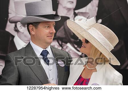 A man in grey morning dress with a top hat, blue tie and matching handkerchief and wearing a badge for the Royal Enclosure at Ascot is looking shocked at his wife, who is smiling back at him. The portrait shows their heads and shoulders turned towards... View Large Photo Image Stock Photograph - A man in grey morning dress with a top hat, blue tie and matching handkerchief and wearing a badge for the Royal Enclosure at Ascot is looking shocked at his wife, who is smiling back at him. The portrait shows their heads and shoulders turned towards.... Fotosearch