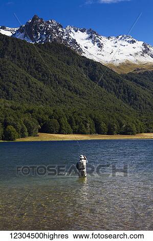 Stock Photograph - A man practices fly fishing at Mavora Lake; Mavora, Southland, New Zealand. Fotosearch