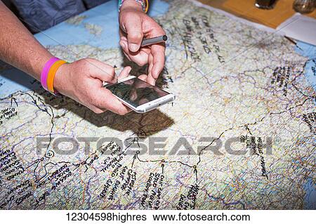 Stock Photograph - A man traces his European trip on a map; Bled, Slovenia. Fotosearch