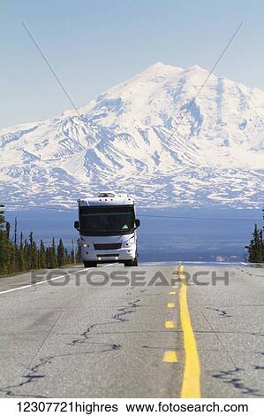 Stock Photograph - A motor home heads down the Glenn Highway outside of Glennallen, Alaska with Mount Drum in the background. Interior Alaska. Summer.. Fotosearch