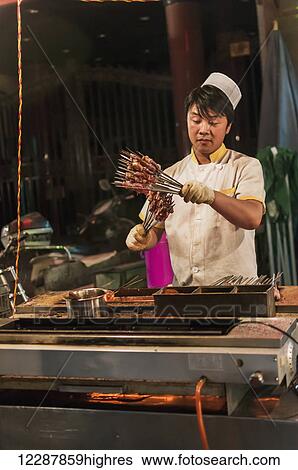 A Muslim Man Preparing Some Mutton In His Traditional Barbecue; Xian, Shaanxi Province, China View Large Photo Image Stock Photograph - A Muslim Man Preparing Some Mutton In His Traditional Barbecue; Xian, Shaanxi Province, China. Fotosearch