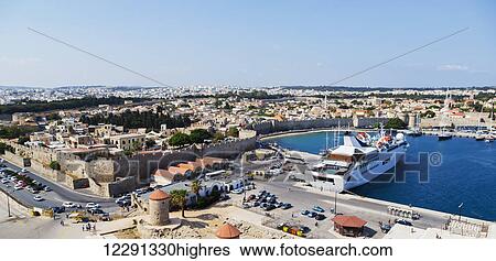 A panoramic skyline view of the port in Rhodes, Greece with a small cruise ship and view of the historic walled village on the Aegean Sea; Rhodes, Greece View Large Photo Image Stock Photograph - A panoramic skyline view of the port in Rhodes, Greece with a small cruise ship and view of the historic walled village on the Aegean Sea; Rhodes, Greece. Fotosearch