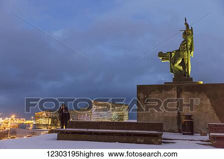 A person talking on a cell phone stands below the statue of Angolfur Arnarson, the first setteler of Reykjavik, by Einar Jonsson, sitting above Arnarholl Park at twilight; Reykjavik, Iceland View Large Photo Image Stock Photograph - A person talking on a cell phone stands below the statue of Angolfur Arnarson, the first setteler of Reykjavik, by Einar Jonsson, sitting above Arnarholl Park at twilight; Reykjavik, Iceland. Fotosearch