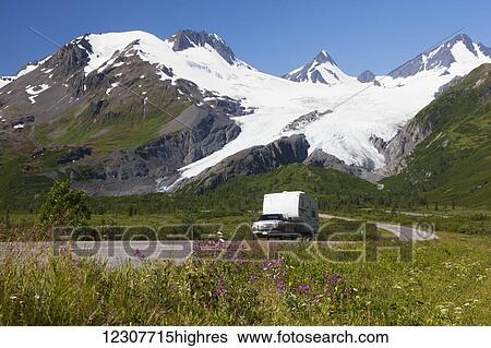 Stock Photograph - A pickup pulls a camp trailer down the Richardson Hwy with Worthington Glacier showing in background, Southcentral Alaska, USA. Fotosearch