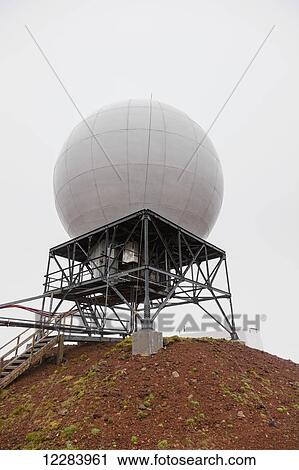 Stock Image - A radar dome sits atop a red dirt hill, St. Paul Island, Southwestern Alaska, USA, Summer. Fotosearch