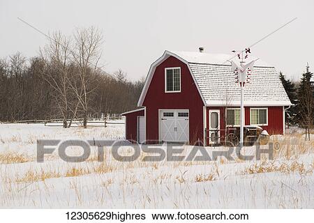 Stock Photograph - A red barn house in the country in winter; Winnipeg, Manitoba, Canada. Fotosearch