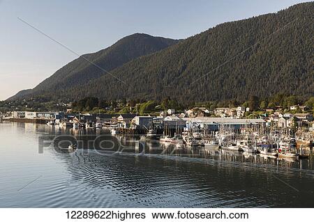 A Small boat motors out of Sitka Harbor, Houses and Fishing Boats in the background, Sitka, Southeast Alaska, USA, Summer View Large Photo Image Stock Photograph - A Small boat motors out of Sitka Harbor, Houses and Fishing Boats in the background, Sitka, Southeast Alaska, USA, Summer. Fotosearch