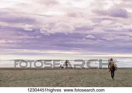 Stock Photograph - A sunset at the surf beach of Piha, just outside of Auckland; Piha, Auckland, New Zealand. Fotosearch