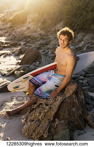 A surfer holding his surfboard on the beach; Tarifa, Cadiz, Andalusia, Spain View Large Photo Image Stock Photograph - A surfer holding his surfboard on the beach; Tarifa, Cadiz, Andalusia, Spain. Fotosearch
