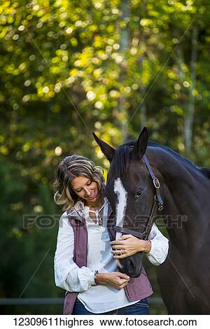 A teenage girl stands with her female thoroughbred horse at Folly Farm; Chapel Hill, North Carolina, United States of America View Large Photo Image Stock Photograph - A teenage girl stands with her female thoroughbred horse at Folly Farm; Chapel Hill, North Carolina, United States of America. Fotosearch