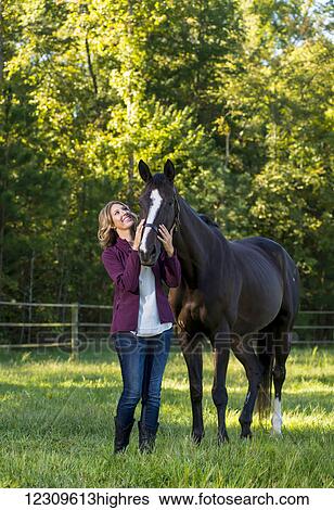 A teenage girl stands with her female thoroughbred horse at Folly Farm; Chapel Hill, North Carolina, United States of America View Large Photo Image Stock Photograph - A teenage girl stands with her female thoroughbred horse at Folly Farm; Chapel Hill, North Carolina, United States of America. Fotosearch