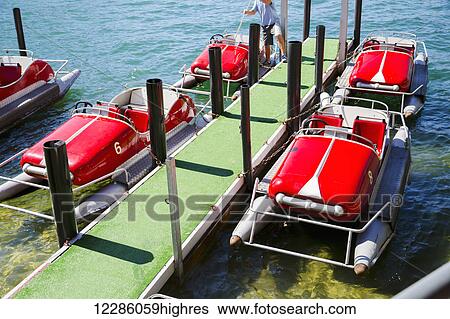 Stock Photograph - A tourist attraction at Lugano Lake to rent paddle pontoon boats on the lake; Lugano, Switzerland. Fotosearch