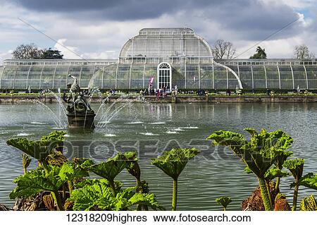 Stock Photograph - A view of The Palm House from across the lake in Kew Gardens; London, England. Fotosearch