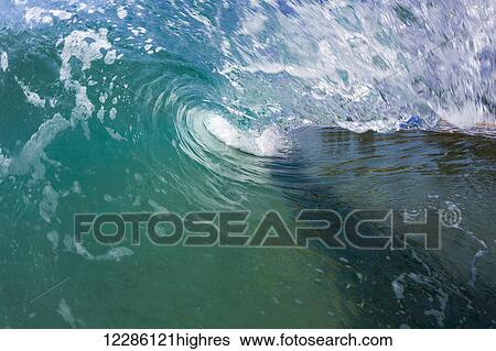 Stock Photograph - A wave curls into the beach in the Indian Ocean; Sri Lanka. Fotosearch