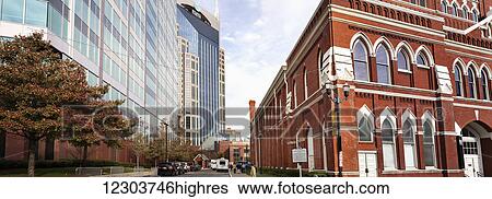 Stock Photograph - A wide, horizontal shot showing the old Ryman Auditorium on the right and new, modern high-rise buildings on the left in downtown Nashville; Nashville, Tennessee, United States of America. Fotosearch
