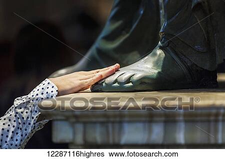Stock Photograph - A woman's hand touches the foot of a statue, St. Peter's Basilica; Rome, Italy. Fotosearch