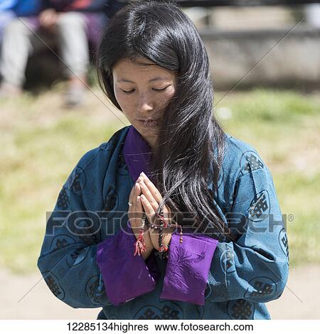 Stock Photograph - A young buddhist woman praying; Thimphu, Bhutan. Fotosearch